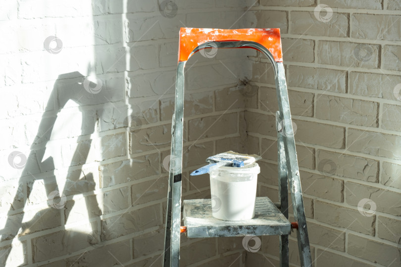 Скачать Идет процесс покраски, стремянка и малярные инструменты, ремонт внутренних стен, внутренняя отделка, домашний декор и защита стен. фотосток Ozero