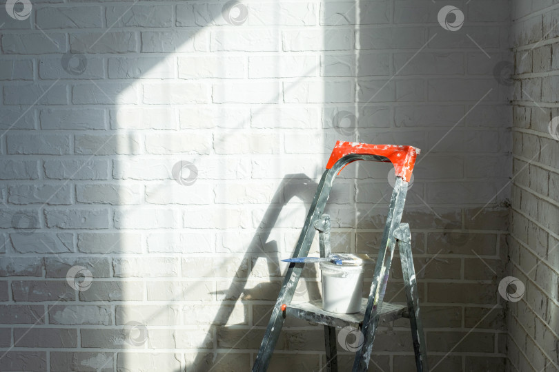 Скачать Покраска и декорирование помещений, стремянка с ведром для краски, подготовка поверхности для отделки стен, перепланировка интерьера, профессиональное обновление. фотосток Ozero
