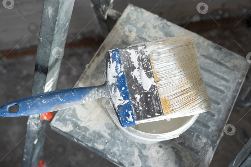 Скачать Лестница с краской и кистью, подготовка поверхности к покраске, отделка дома, ремонтные работы, улучшение интерьера, детали декора помещения. фотосток Ozero