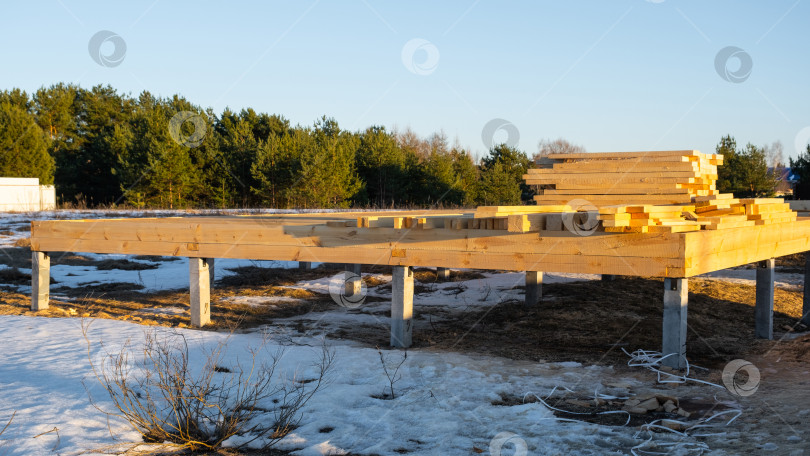 Скачать Основание фундамента из деревянных балок, подготовка площадки для каркаса дома, строительство из бруса, этап сборки, наружный проект, плотницкие работы, новый фундамент. фотосток Ozero