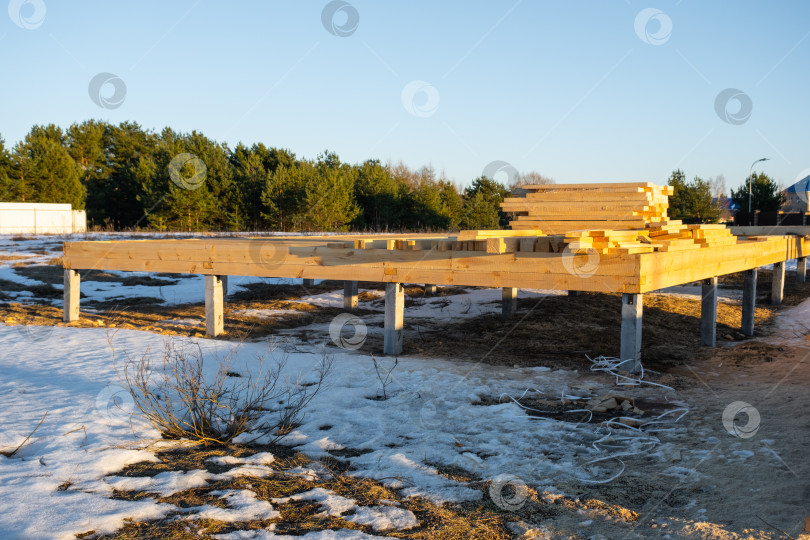 Скачать Деревянные балки, установленные на сваях, каркас деревянного дома, конструкция фундамента, подготовка строительной площадки, стадия строительства, столярная сборка, опоры. фотосток Ozero