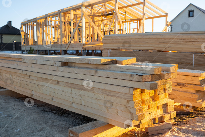 Скачать Заготовленный лесоматериал, балки, доски для сборки каркаса дома, рабочее место, строительные материалы, столярные изделия, деревянные конструкции, подготовка фундамента, принадлежности для строительной площадки. фотосток Ozero