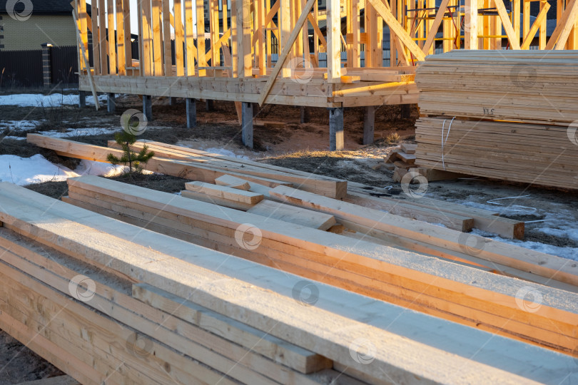 Скачать Строительная площадка с фундаментом и древесиной, досками и балками, подготовка к строительству деревянного каркасного дома, строительные материалы, планирование внешней сборки, штабелирование пиломатериалов. фотосток Ozero