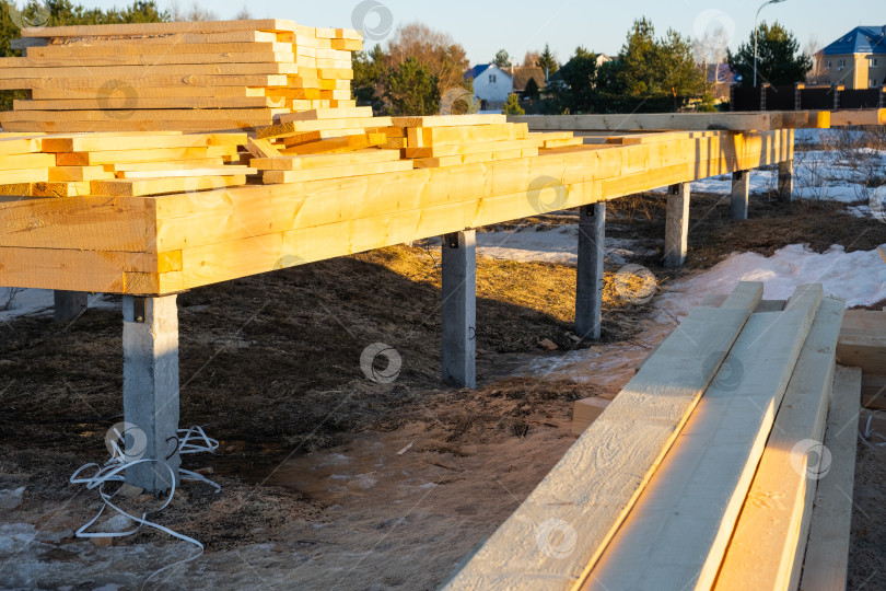 Скачать Свайно-винтовой фундамент для деревянного каркасного дома, основание для установки, строительная площадка, первый этап строительства, земляные работы, монтаж деревянных балок. фотосток Ozero