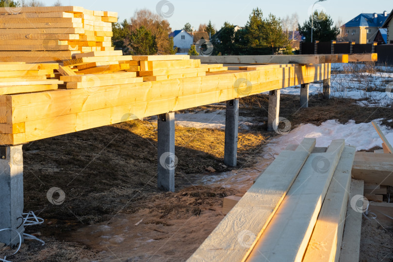 Скачать Основание деревянного каркасного дома на винтовых сваях, этап монтажа, сборка фундамента, установка свай, плотницкие работы, этап строительства, деревянные балки, ход строительства. фотосток Ozero