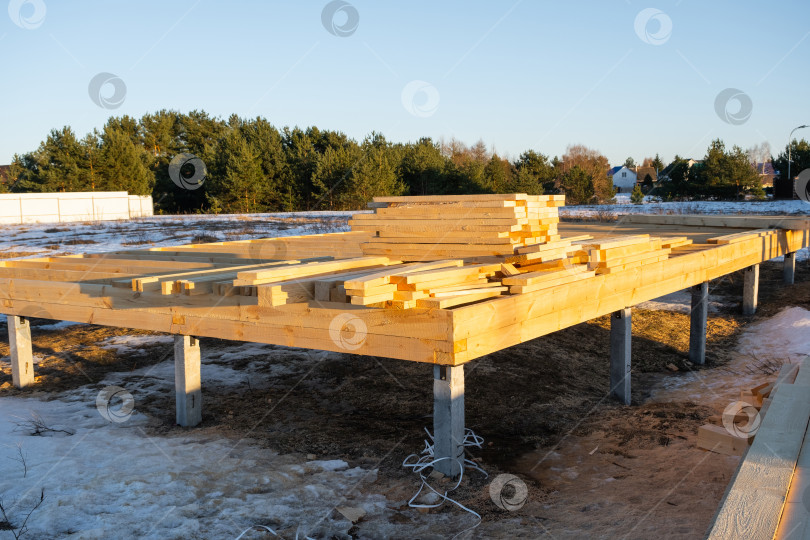 Скачать Фундамент на винтовых сваях для каркасного дома, строительная площадка, подготовка деревянного основания, сборка конструкций для будущих деревянных стен, опоры на уровне земли. фотосток Ozero