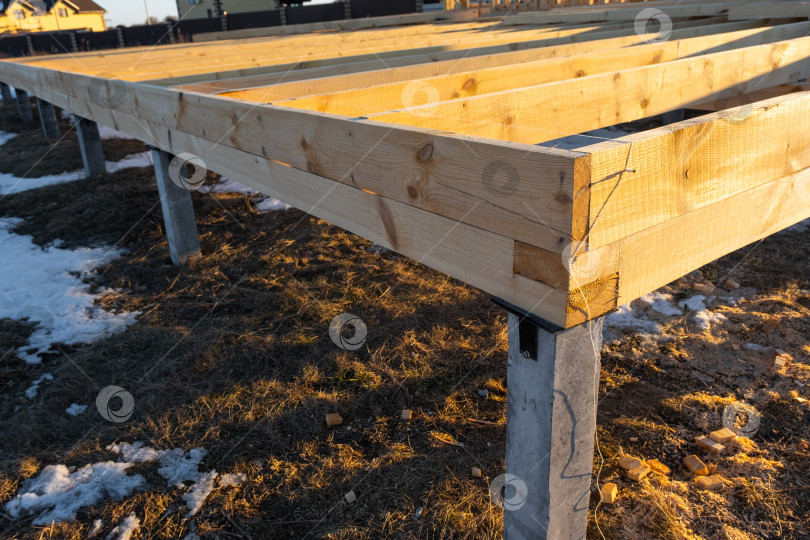 Скачать Фундамент на винтовых сваях крупным планом, монтаж деревянного основания пола, будущий каркасный дом, наружная конструкция, опоры основания здания, первый этап строительства. фотосток Ozero