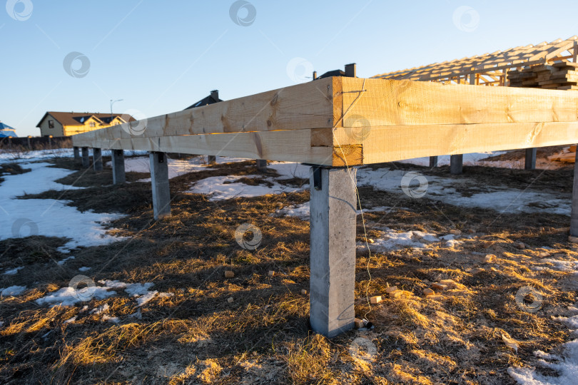 Скачать Строительство деревянного каркаса на сваях, устройство фундаментных балок, подготовка площадки под строительство дома, этап монтажа, столярно-монтажные работы, свайный фундамент, установка каркаса. фотосток Ozero