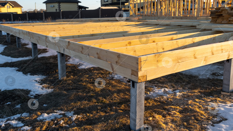 Скачать Фундаментная платформа с деревянными балками, монтаж винтовых свай для каркасного дома, подготовка основания площадки, опорное основание для ступеней настенного и напольного монтажа. фотосток Ozero