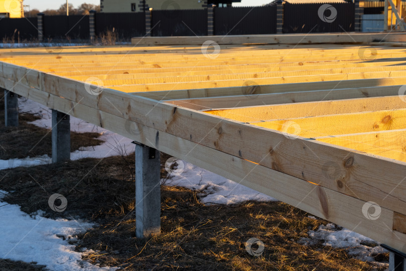 Скачать Свайный фундамент для деревянного каркасного дома, фундаментные балки, этап монтажа, строительство площадки, фундаментная конструкция первой очереди, строительная платформа, виден фундамент. фотосток Ozero