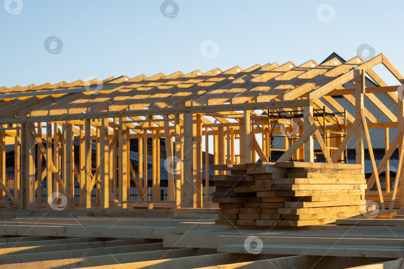Скачать Каркас деревянного дома, монтаж балок на фундаментные сваи, ход работ по опалубке, сборка каркаса, крепежные опоры, строительная площадка, наружные строительные работы. фотосток Ozero
