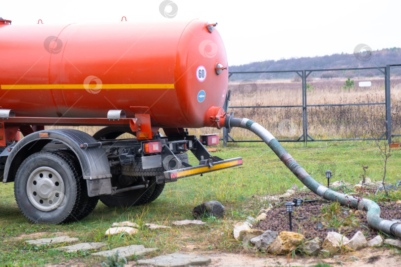 Скачать Канализационный вакуумный грузовик, откачивающий отходы из септика частного дома, услуга по вывозу и утилизации жидких отходов, концепция бизнеса в области санитарии. фотосток Ozero