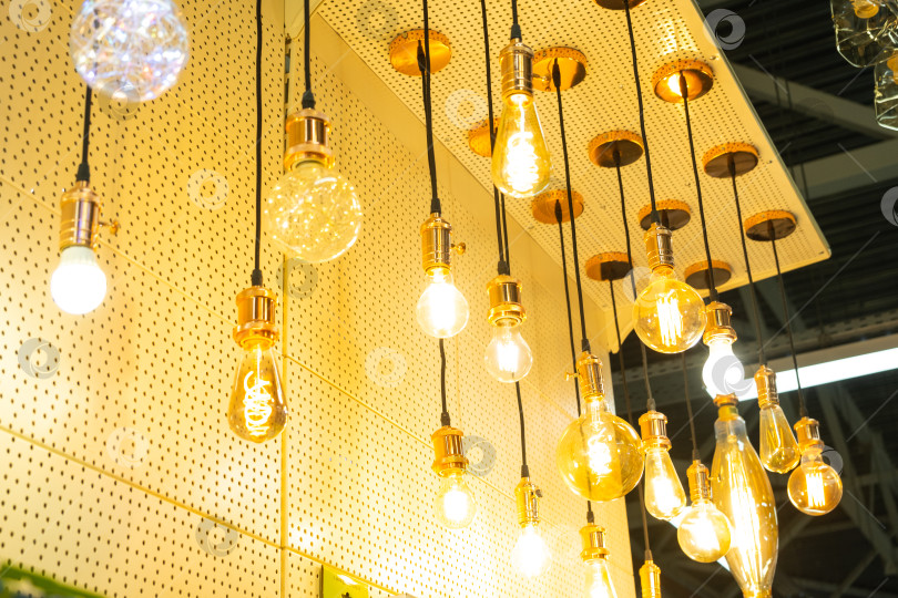 Скачать Дизайнерские ретро-светильники в витрине магазина, креативное подвесное освещение, винтажные лампы накаливания, акцент в дизайне интерьера, витрина магазина, художественный световой декор. фотосток Ozero