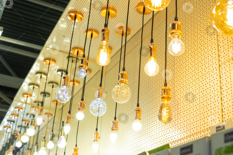Скачать Серия декоративных ретро-лампочек в витрине магазина, винтажные стеклянные подвесные светильники, стильный дизайн освещения магазина, современный интерьер, элегантная атмосфера. фотосток Ozero
