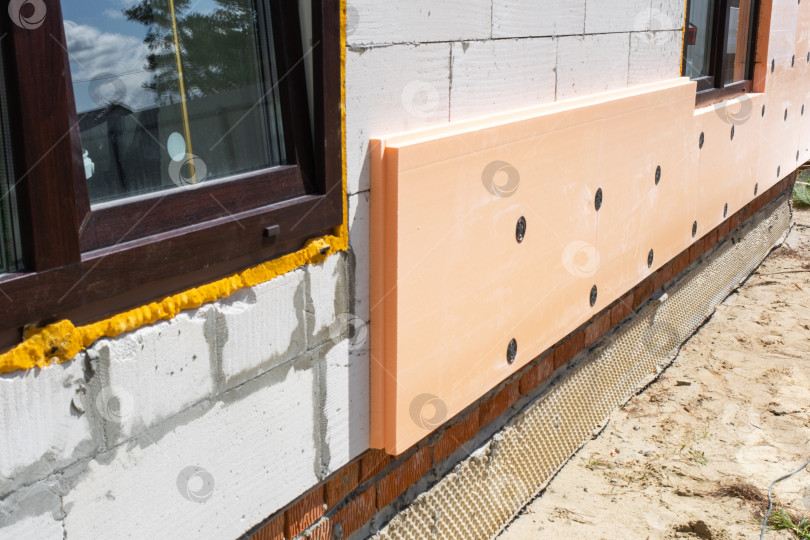Скачать Внешнее утепление дома пенопластовыми панелями, теплозащита стен, система утепления фасадов, строительные работы, энергосбережение и тепловая эффективность. фотосток Ozero