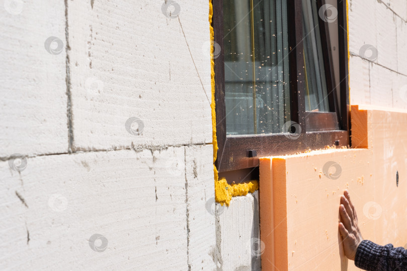 Скачать Утеплитель из пенопласта, прикрепленный к стене здания, термическая модернизация, энергосбережение фасада, современная облицовка, процесс монтажа, строительство на месте, монтаж. фотосток Ozero