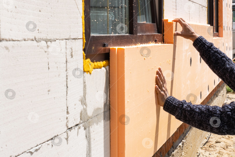 Скачать Нанесение пенополистирольных панелей на фасад дома, монтаж наружных стен, энергоэффективность, ремонт, строительные технологии, защита стен, установка плит. фотосток Ozero