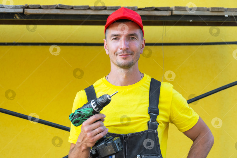 Скачать Портрет строителя с аккумуляторной отверткой, ремонт стен дома, благоустройство своими руками, мастер на все руки, инструменты, частный бизнес-проект, консультация. фотосток Ozero