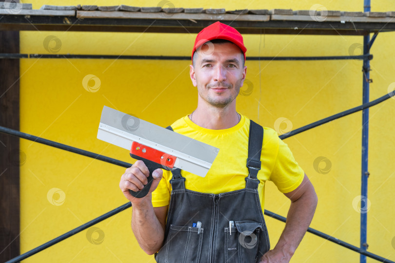 Скачать Портрет частного мастера-ремонтника с широким шпателем, строительные инструменты, ремонт стен на дому, частный бизнес, строительство дома, сделай сам, плотницкие работы, консультации. фотосток Ozero