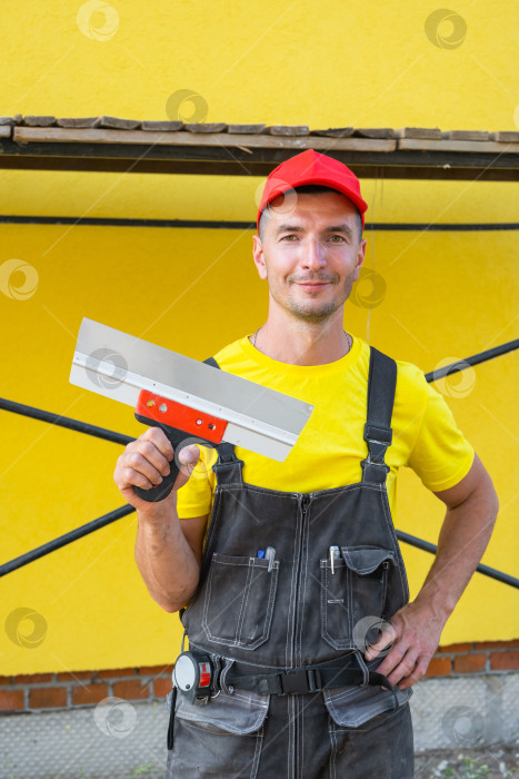 Скачать Портрет строителя, шпатель для штукатурки в руках, строительная площадка, бизнес по ремонту частного дома, услуги разнорабочего, сделай сам, ремонт стен своими руками, навыки. фотосток Ozero