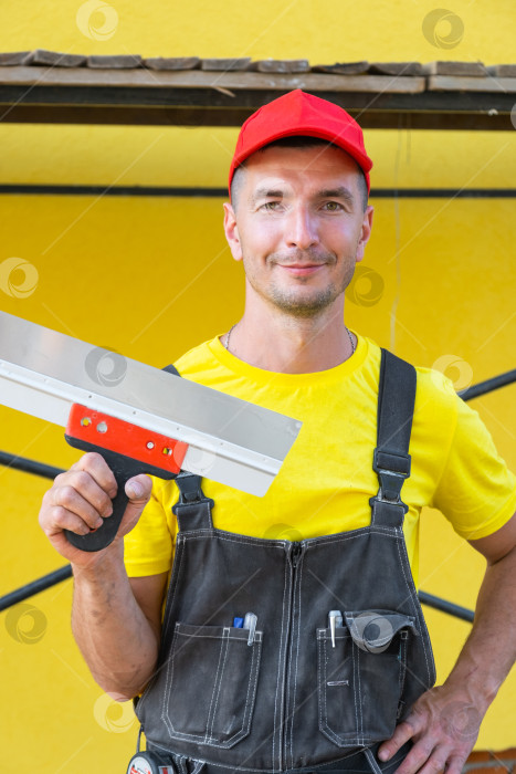 Скачать Портрет строителя со шпателем, ремонт штукатурки, бизнес по ремонту дома, мастерство в отделочных работах, инструменты для ухода за домом. фотосток Ozero