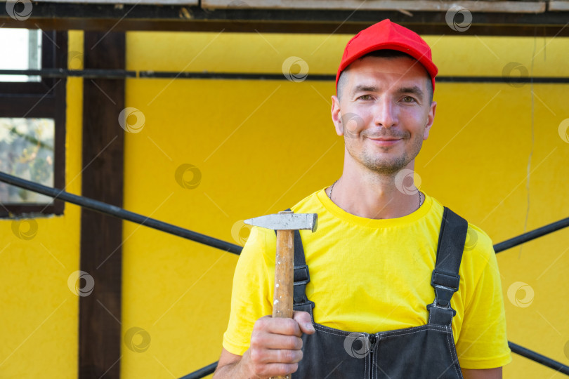 Скачать Портрет строителя с молотком, готовый к строительству дома, частный специалист по ремонту дома, сделай сам, обрамление, забивание гвоздей, консультации на строительной площадке. фотосток Ozero