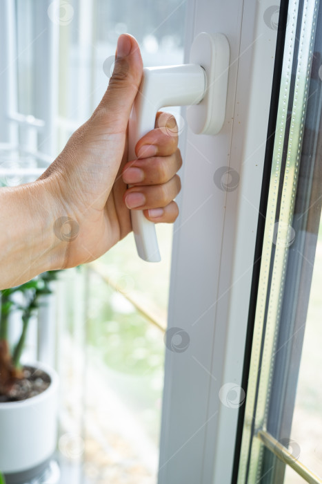 Скачать Крупный план современной оконной ручки из ПВХ, установка системы микровентиляции, звуконепроницаемые двойные стеклопакеты, контроль тяги, услуги по установке бизнес-оборудования. фотосток Ozero