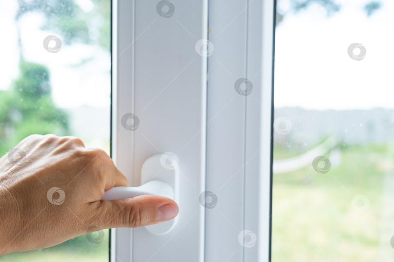 Скачать Пластиковое окно, открывающееся с помощью белой ручки, фурнитуры премиум-класса, для комфортного проветривания, звукоизоляции, защиты от сквозняка и установки в офисе. фотосток Ozero