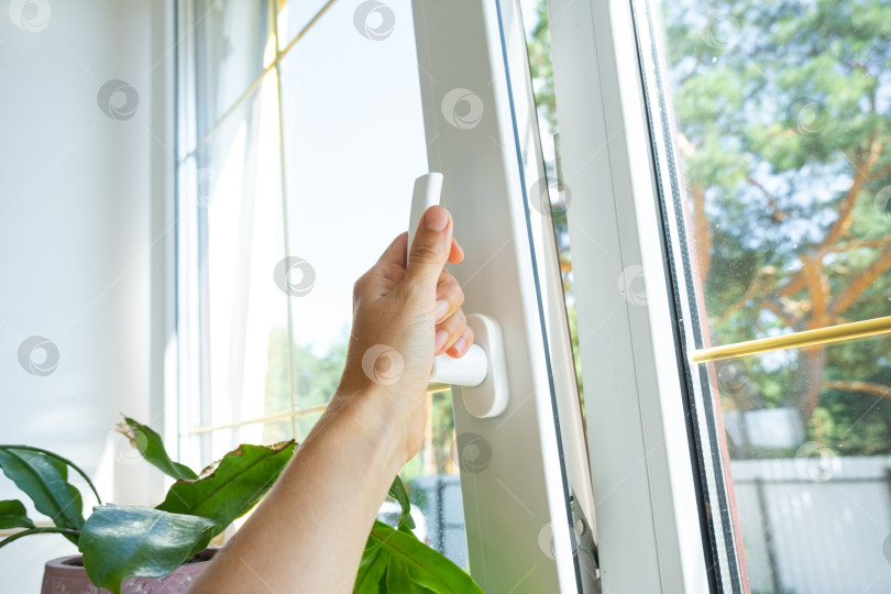 Скачать Рука бережно проветривает помещение через окно из ПВХ с энергосберегающим двойным остеклением, защитой от сквозняков, регулировкой, установкой и шумоподавлением. фотосток Ozero