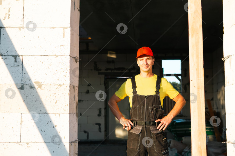 Скачать Геодезист на строительной площадке измеряет дверные и оконные проемы, разметку, расположение внутренних перегородок и стен, точную подгонку к монтажным работам. фотосток Ozero