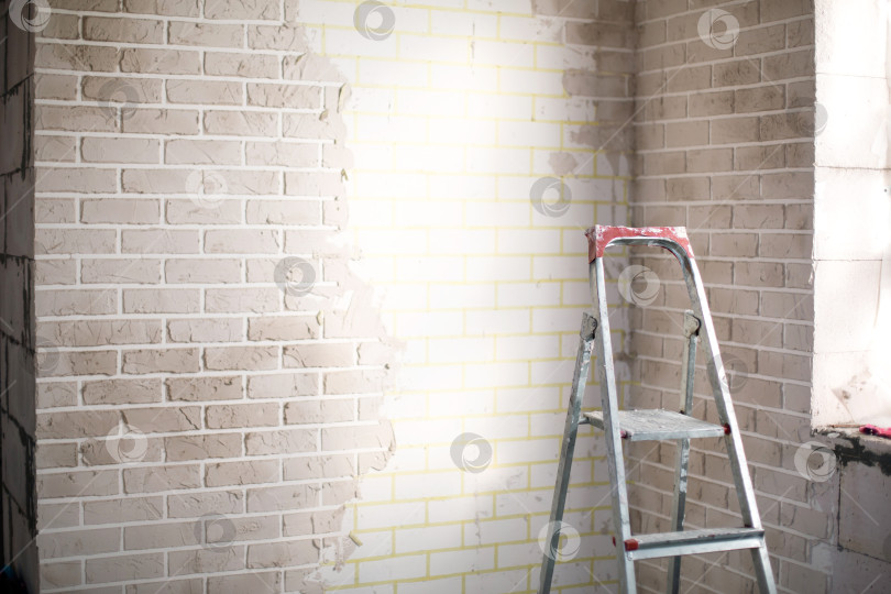 Скачать Внутренняя отделка стен в доме, подготовка к покраске или оштукатуриванию, ремонт, стремянка для работы на высоте, профессиональный ремонт и отделка. фотосток Ozero