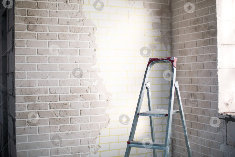 Скачать Ремонт интерьера дома, процесс отделки стен, стремянка для потолочных и настенных работ, подготовка помещений, строительные проекты и проекты по ремонту помещений. фотосток Ozero