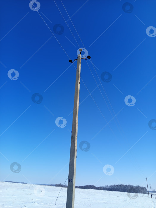 Скачать Столб электропередачи в зимнем поле. фотосток Ozero