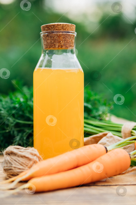 Скачать Свежая морковь на деревянном фоне. Блюда для вегетарианцев. Овощи домашнего приготовления, экологически чистая, здоровая пища. Стеклянный кувшин с морковным соком на деревянном столе. фотосток Ozero