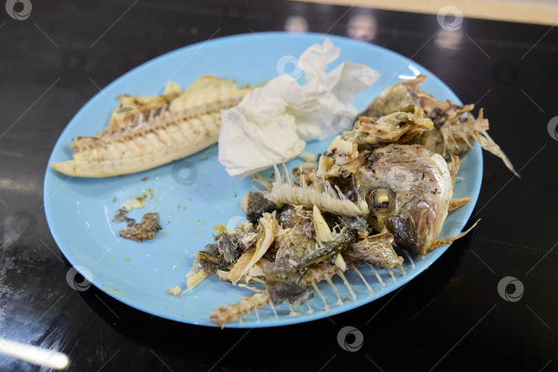 Скачать Вкуснейшая рыба дорадо, поданная на тарелке, демонстрирует хрустящую золотистую кожицу и нежные косточки после сытного ужина фотосток Ozero