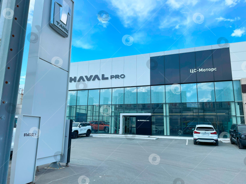 Скачать Тюмень, Россия - 10 июня 2025 года: Современный дилерский центр Haval pro демонстрирует новые автомобили в ярком городском освещении в дневное время фотосток Ozero