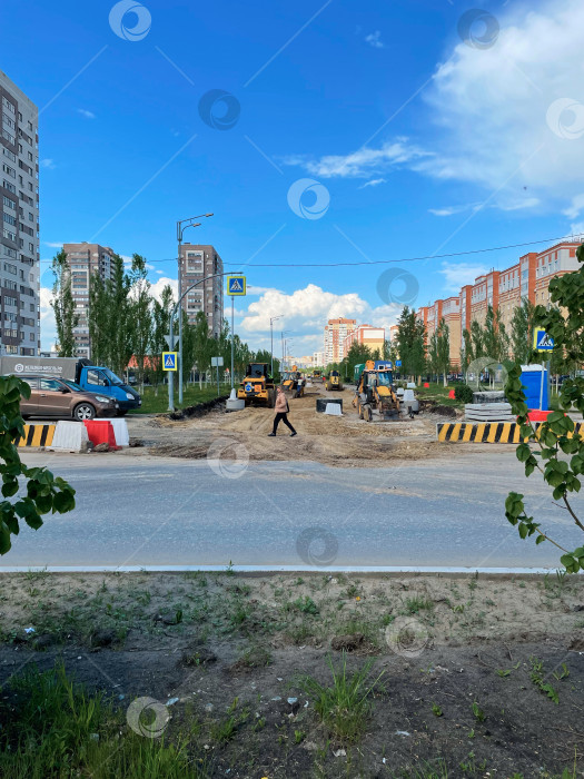 Скачать Тюмень, Россия - 10 июня 2025 года: Тяжелая техника работает на строительстве дороги вдоль оживленной городской улицы фотосток Ozero
