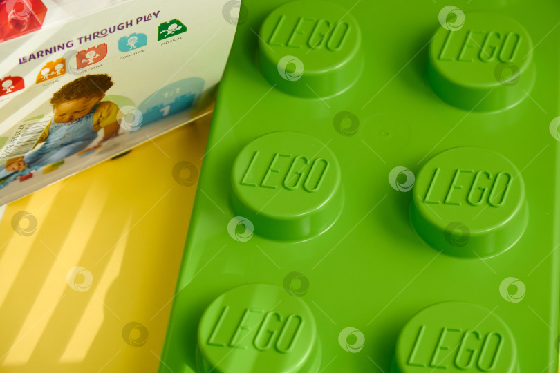 Скачать Тюмень, Россия - 8 июля 2025 года: Яркий зеленый конструктор Lego выделяется на ярком и красочном фоне. фотосток Ozero