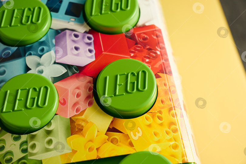 Скачать Тюмень, Россия - 8 июля 2025 года: Яркий зеленый конструктор Lego выделяется на ярком и красочном фоне. фотосток Ozero