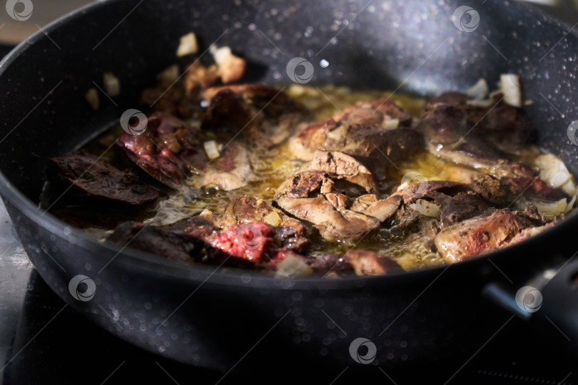 Скачать Приготовление кусочков печени на сковороде с поднимающимся паром на фоне кухонных приборов фотосток Ozero