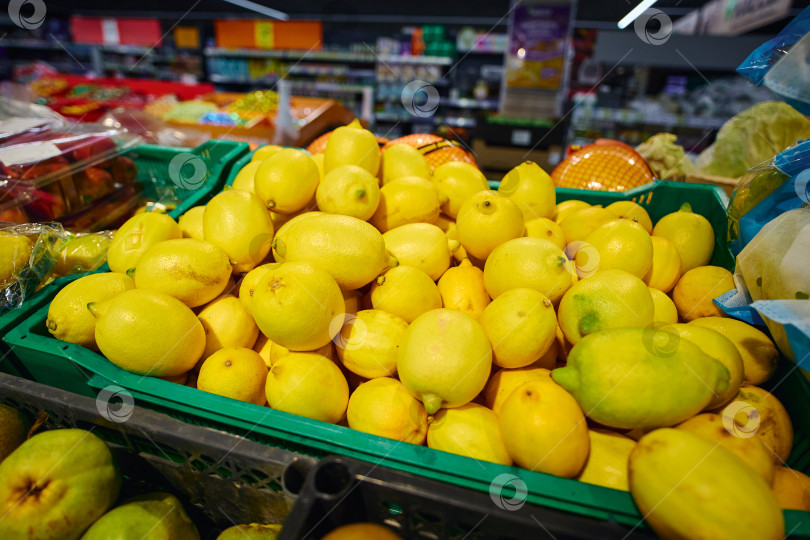 Скачать В продуктовом магазине в зеленой корзине лежат горы лимонов фотосток Ozero