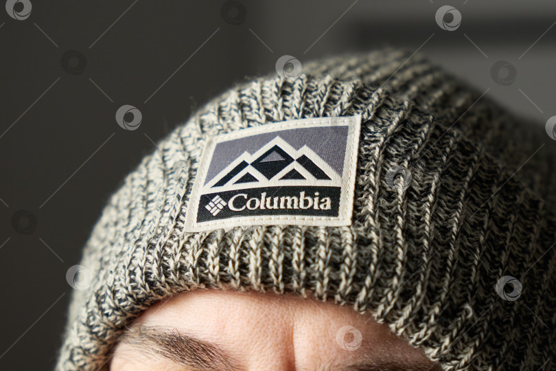 Скачать Тюмень, Россия - 11 декабря 2025 года: Логотип columbia на трикотажной ткани с горным рисунком и названием компании, четко отображенным крупным планом. фотосток Ozero