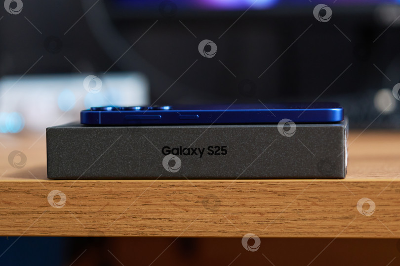 Скачать Тюмень, Россия - 11 декабря 2025 года: Показаны две коробки Samsung S25, стоящие на деревянном полу. фотосток Ozero