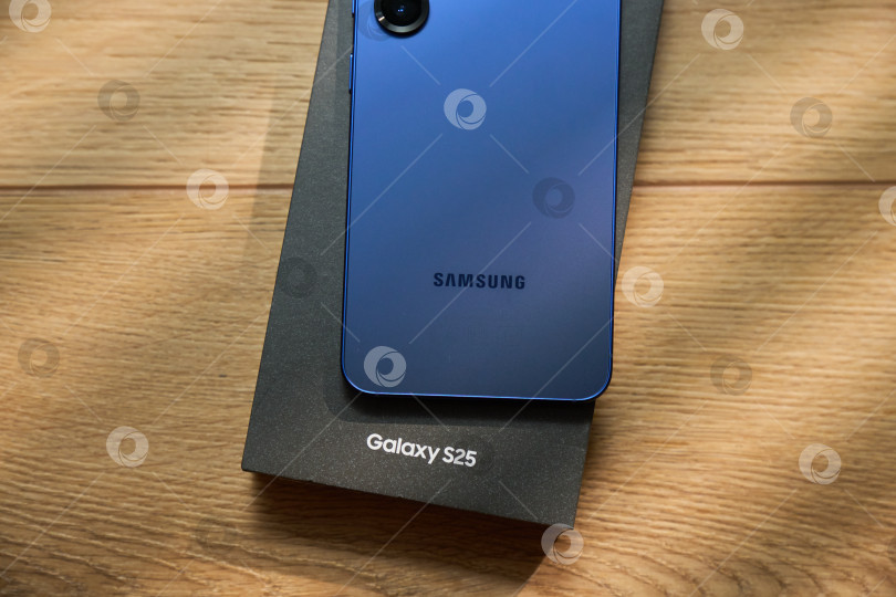 Скачать Тюмень, Россия- 11 декабря 2025 года: Модели Samsung S25 демонстрируются на простом фоне с мягким светом и тенями в дневное время фотосток Ozero