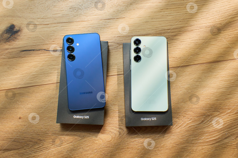 Скачать Тюмень, Россия- 11 декабря 2025 года: Модели Samsung S25 демонстрируются на простом фоне с мягким светом и тенями в дневное время фотосток Ozero