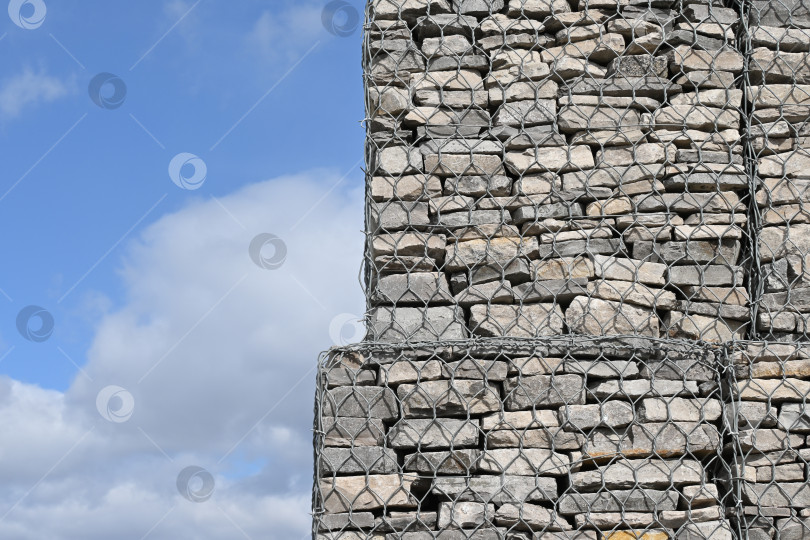 Скачать Стена из габионов на фоне голубого неба фотосток Ozero
