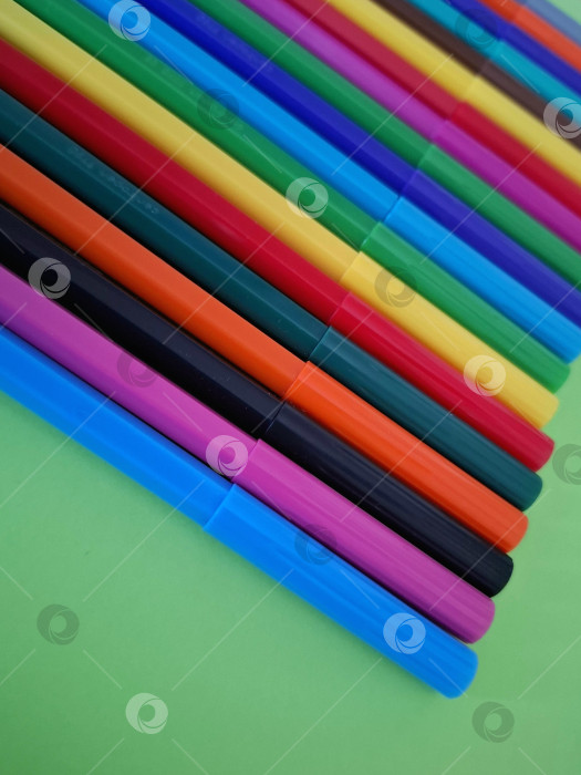 Скачать Яркие, разноцветные маркеры, фломастеры на зеленом фоне фотосток Ozero