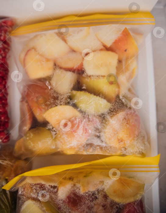 Скачать Фрукты и ягоды упаковывают в полиэтиленовые пакеты и хранят в морозильной камере. Свежие и полезные продукты в любое время года. фотосток Ozero