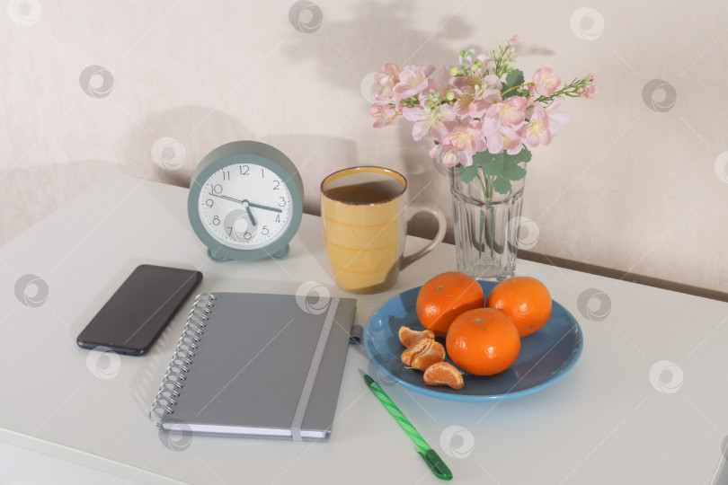 Скачать Уютное утреннее рабочее пространство с будильником, блокнотом, кофе и свежими фруктами фотосток Ozero