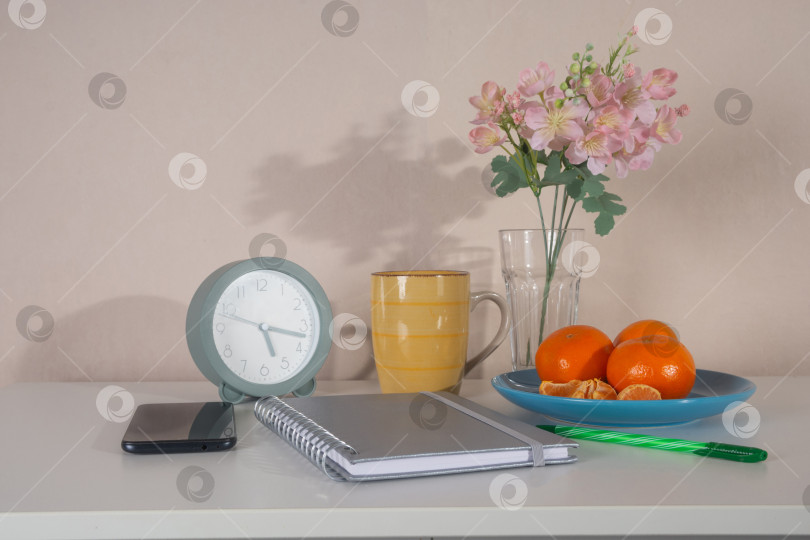 Скачать Уютное место для утренней работы с будильником, блокнотом, кофе и свежими фруктами. Вид спереди. фотосток Ozero